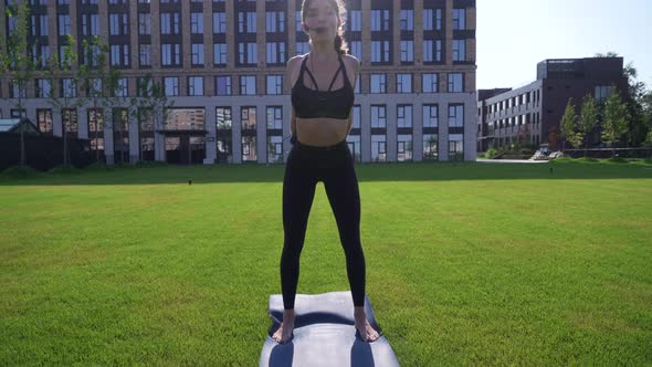 Fitness Instructor Shows Exercise Outdoors in City