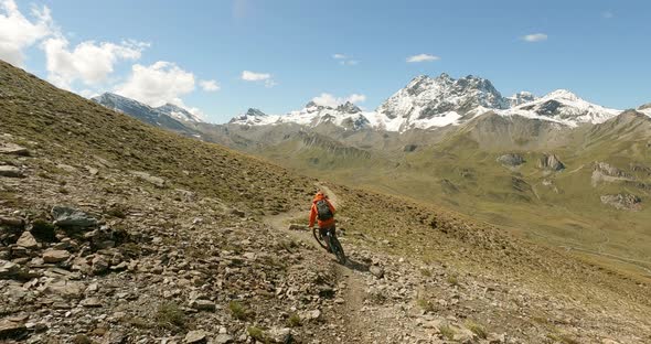 Cool mountain bike turns on a nature single trail in high alpine terrain with amazing view at the sn