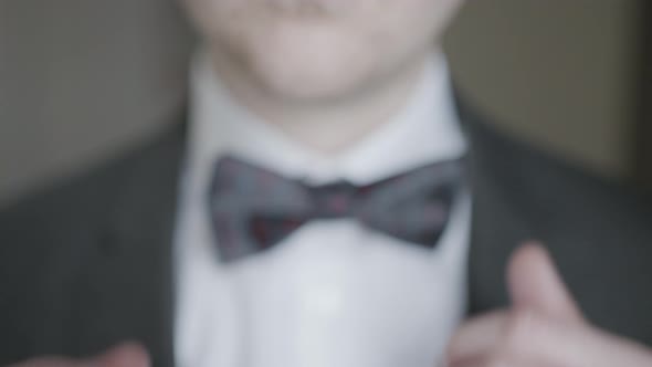 Close-up of gentleman adjusting bow tie