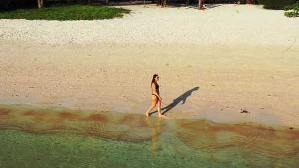 Women best friends on paradise lagoon beach adventure by blue green ocean with white sandy backgroun