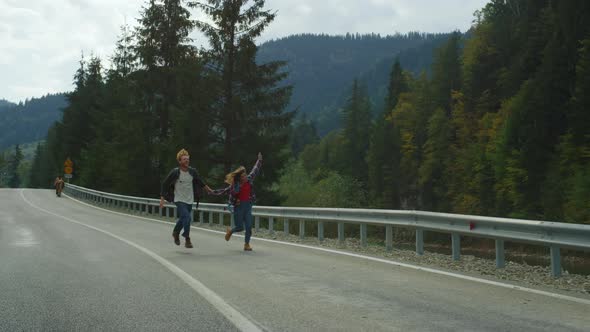 Hikers Running Mountains Road in Green Landscape