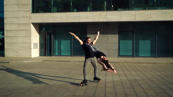 Roller skating acrobats doing extreme stunts near modern building