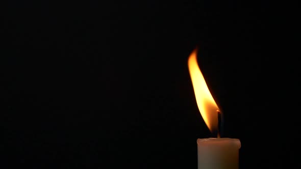 Slow Motion Closeup Burning Single Candle Flame Isolated on Black Background