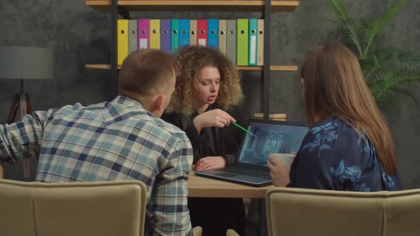 Pretty Female Real Estate Agent Showing House Design to Married Couple