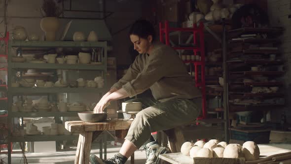 Woman Potter Is Creating Vessel of Wet Clay On Rotating Disk
