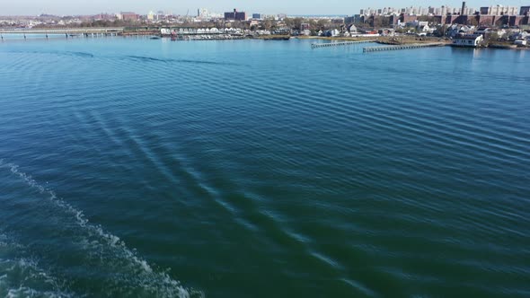 An aerial shot over Grassy Bay in Queens, NY. The camera, tilted down over the water, then tilts up