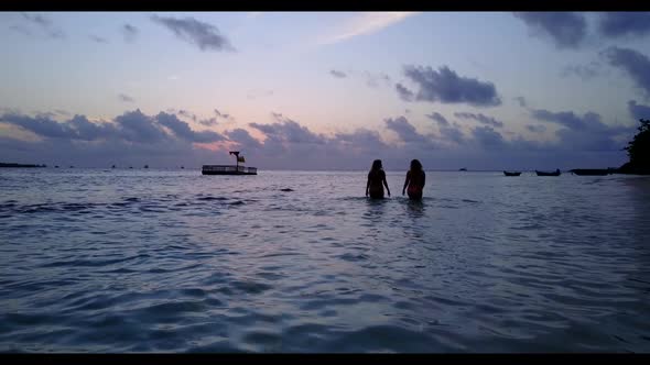 Girls tan on relaxing bay beach trip by blue green sea with white sand background of the Maldives ne