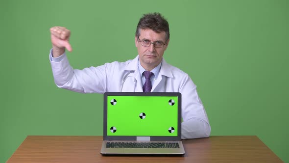 Mature Handsome Man Doctor Against Green Background