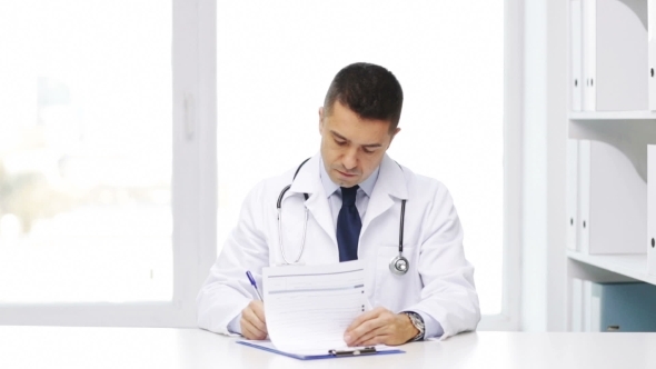 Happy Doctor With Clipboard In Hospital