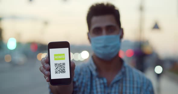 Focus on Male Hand Holding Smartphone with Vaccine Qr Code on Screen Outdoors