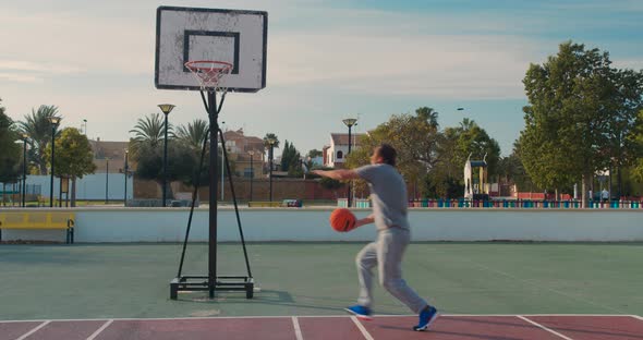 Basketball Player Training. Playing on Basketball Field. Basketball Player Bouncing with the Ball.