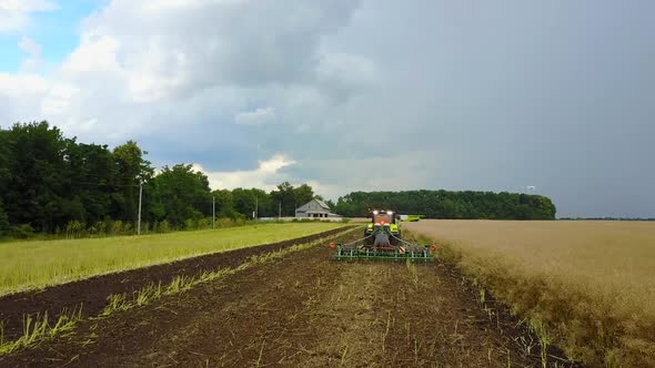 Tractor Preparing Land. Farmer in tractor preparing land with seedbed cultivator