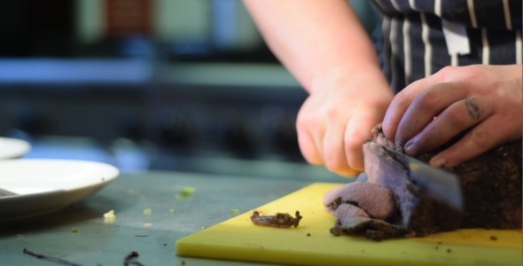 Slicing Meat in Kitchen