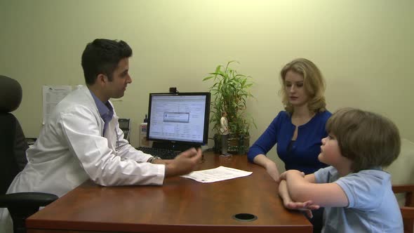 Male Doctor Consults With Mother And Son (4 Of 6)