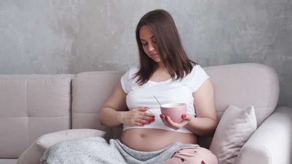 Pregnant Woman Eating Cornflakes with Milk