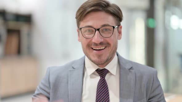 Portrait of Cheerful Businessman Waving at the Camera