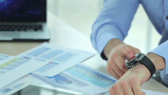 Close Up Of Businessman Points At His Watch alt