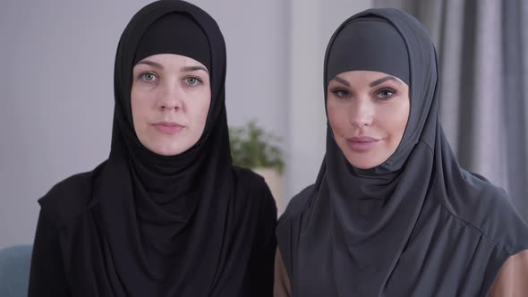 Close-up of Conservative and Modern-looking Muslim Women Looking at Camera and Smiling. Two