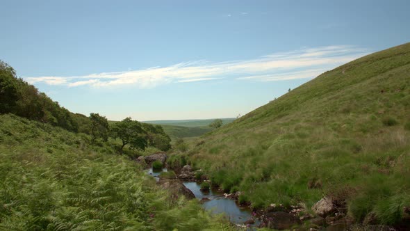 Clouds moving above a peaceful hillside stream, Timelapse