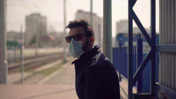 Man In Mask Waiting For Tram.Man Waiting Tram Wearing Protective Mask COVID19 Virus.Pandemic.