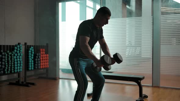 Muscular Male Hardly Working Out with Heavy Dumbbells