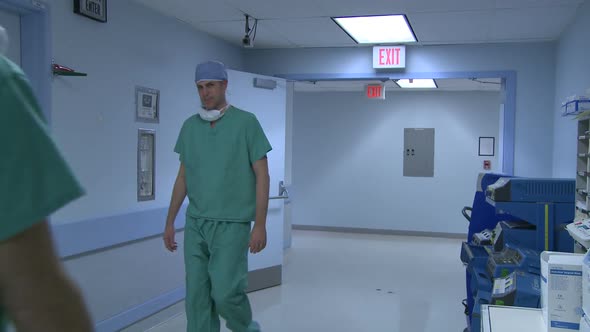 Doctors Acknowledge Each Other In Hospital Hallway