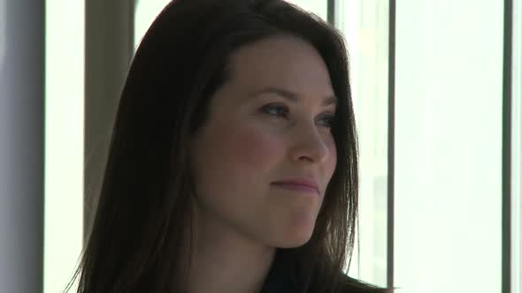 Office Female Smiles As She Looks Toward The Window