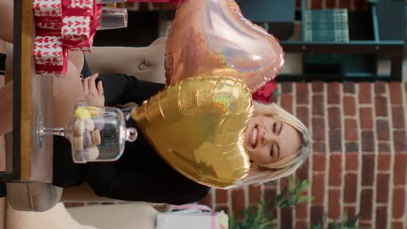 Vertical Video Smiling Beautiful Woman on Valentine Day Holding Helium Heart Shaped Balloons in Room