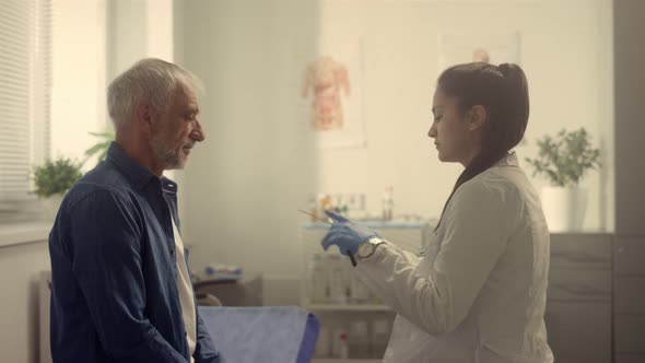 Serious Doctor Checking Senior Patient Throat in Hospital