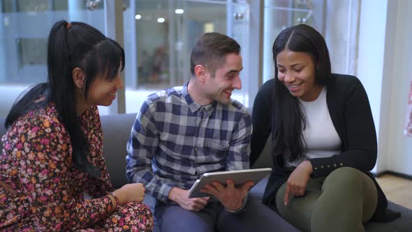 Cheerful multiethnic friends browsing on tablet