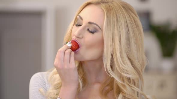 Healthy Attractive Blond Woman Eating A Strawberry 1 alt