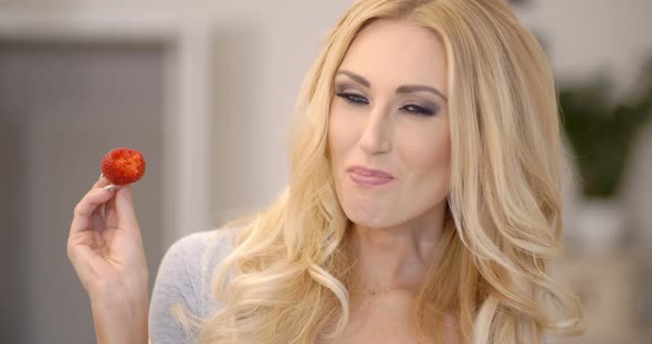 Healthy Attractive Blond Woman Eating A Strawberry 1 alt