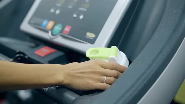 Slow Motion Girl Hand Takes Green Bottle From Treadmill