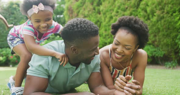 Happy african american couple with two daughters playing in garden