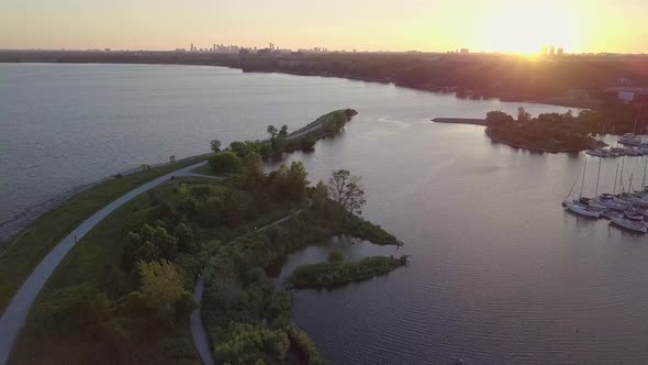 Aerial Sunset Wide Shot Of Park Slides Left Pans Right To Reveal Sailboat Marina Yacht Club Dock In