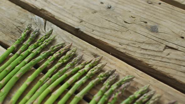 Video of fresh asparagus stalks on wooden background