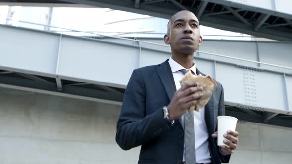 Young Businessman with Sandwich and Paper Cup