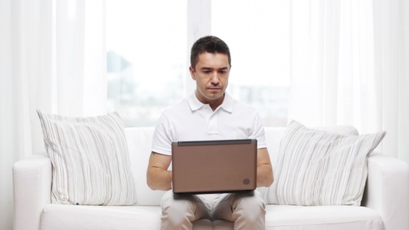 Man Working With Laptop Computer At Home