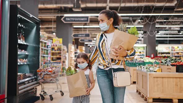 Small Female Kid and Mom with Face Mask in Supermarket