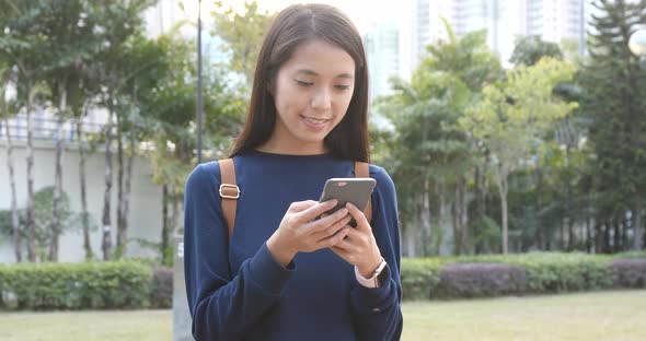 Young woman use of smart phone in city park
