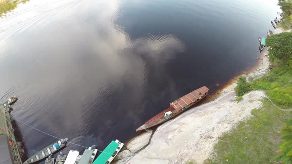 Aerial shot along Amazon River showing river banks and boats