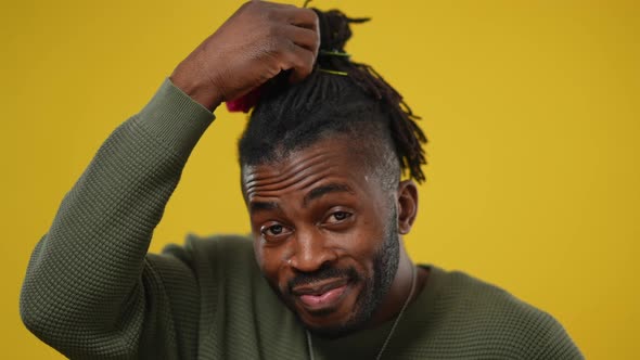 Closeup of Smiling Happy LGBTQ Man Decorating Dreadlocks with Flowers Showing Thumbs Up Smiling