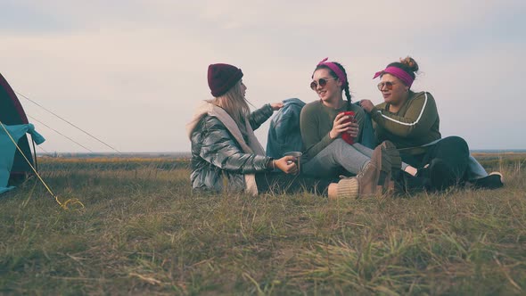 Cheerful Women Cover Friend with Denim Jacket at Tent