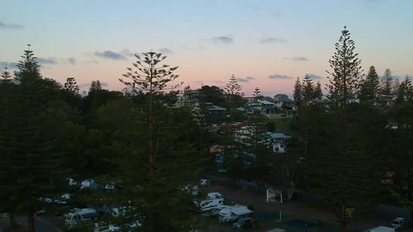 Aerial reveal of beautiful sunset from inside a forrest campsite. Yamba, New south wales, Australia