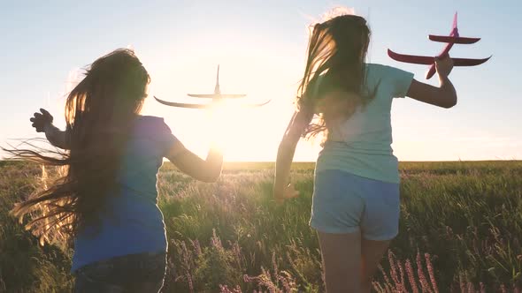 Silhouette of Children Playing on the Plane. Dreams of Flying. Happy Childhood Concept. Two Girls