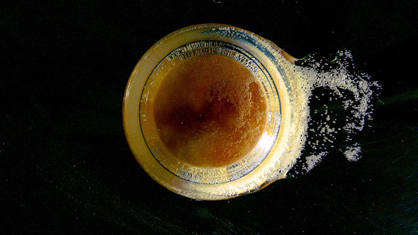 Beer is Pouring into the Glass and Splashing Foam