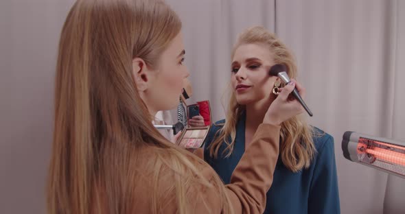 Stylist Doing Makeup For A Model In The Studio