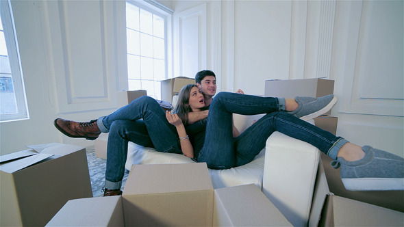 Couple In Love Hugging Lying Down Among The Boxes