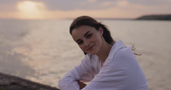 Young Cute Woman Relaxing Sitting on the Pier