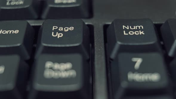 Human Finger Repeatedly Pressing the Num Lock Key on a Black Keyboard